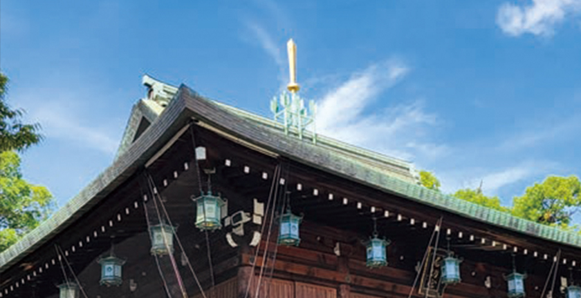 切妻造りの四周に庇を廻した屋根の中央に剣と矢が立つ